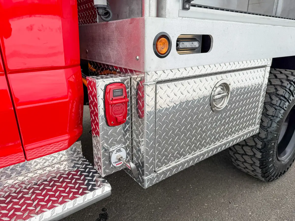 Rear side corner showing marker lights and utility port panel.